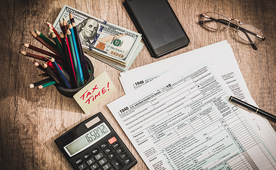 Tax forms with pens and calculator ready to do taxes